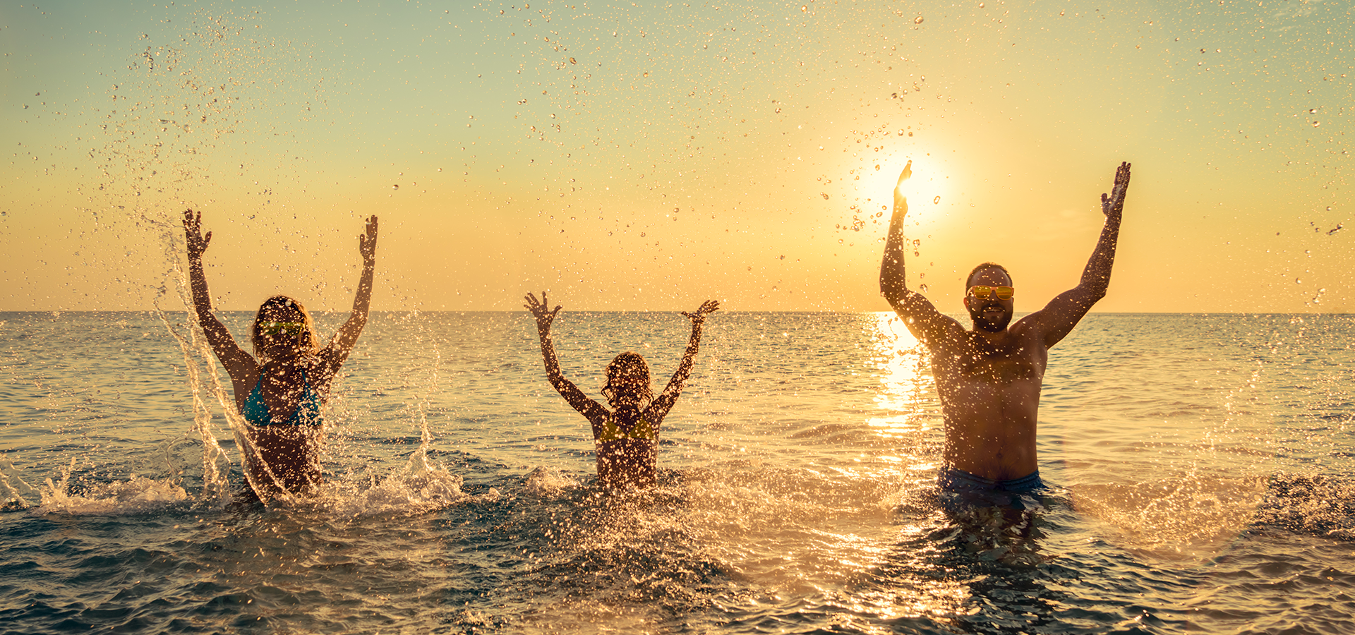 Famiglia in acqua al tramonto